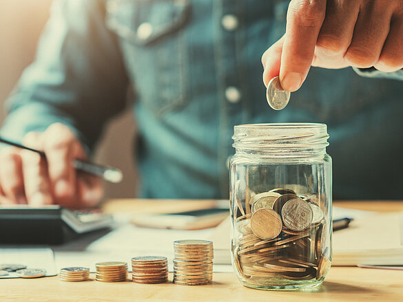 businessman holding coins putting in glass. concept saving money for finance accounting